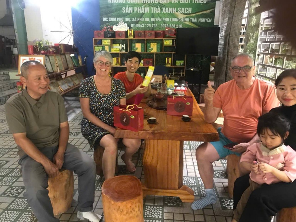 Vợ chồng anh Tuấn tiếp một đoàn khách nước ngoài ghé thăm HTX.
