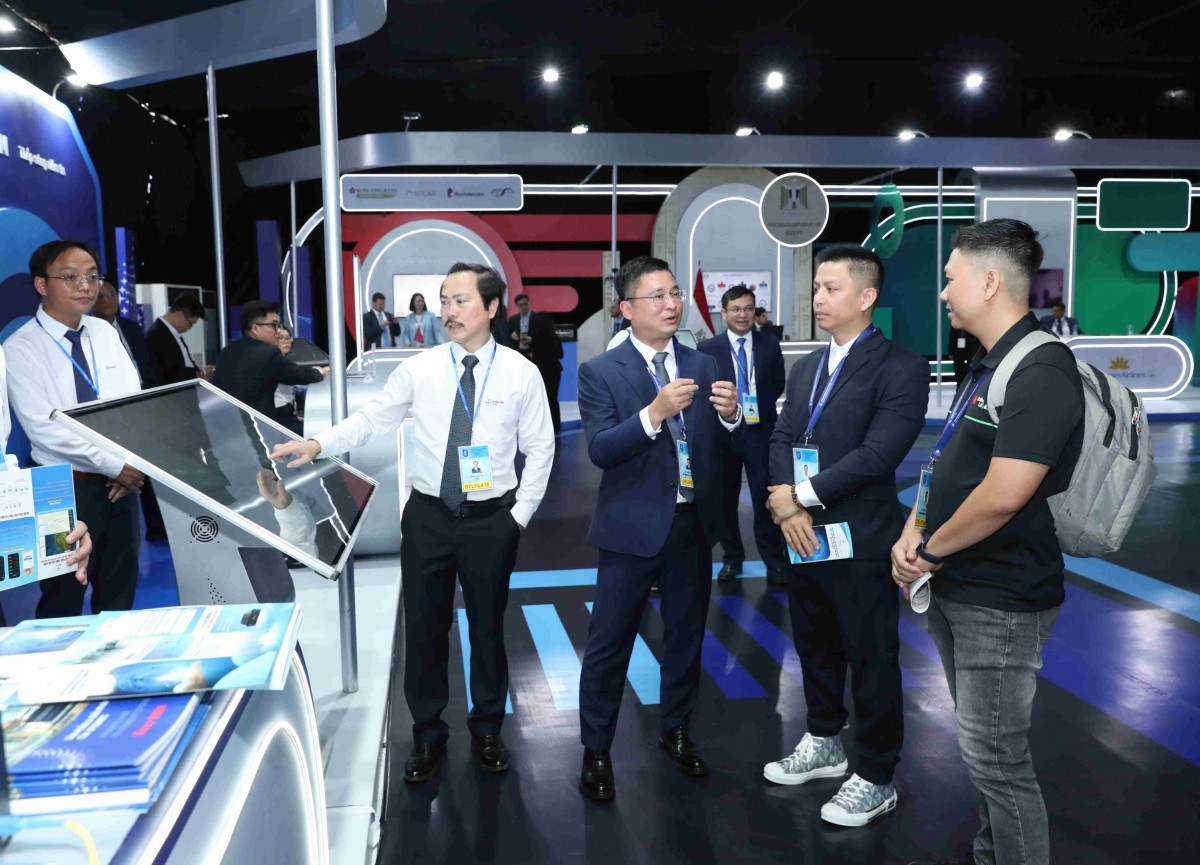 Các đại biểu trong nước, quốc tế tham quan gian trưng bày của EVN tại sự kiện Lễ mở ký Công ước Hà Nội